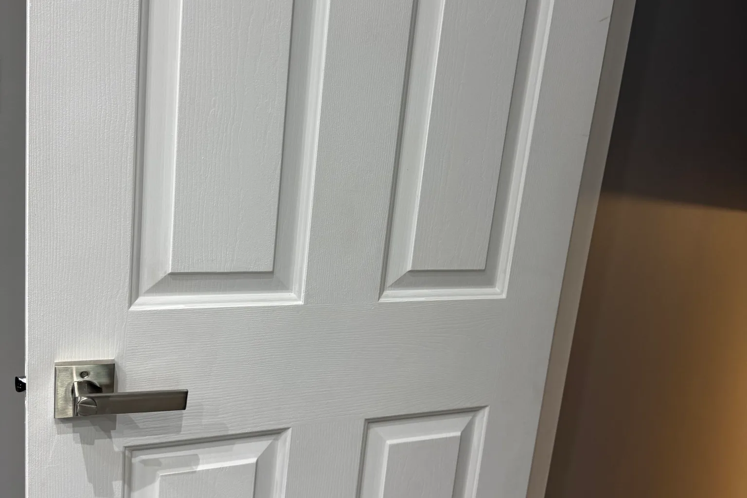 White paneled interior door hanging square in its frame after the hinges were adjusted
